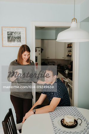 Mid adult couple taking a coffee break at kitchen table