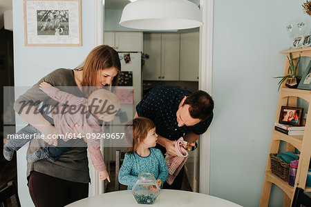 Mid adult couple at table with female toddler and baby son