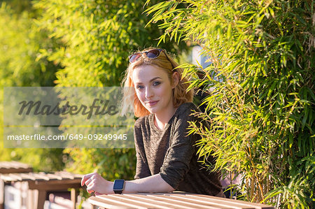 Young woman relaxing in cafe by river in summer