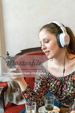 Young woman listening to music with headphones at home