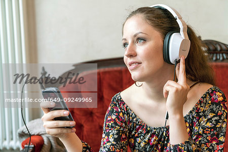 Young woman listening to music with headphones at home