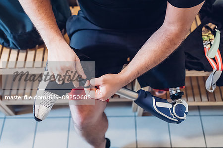 Man with prosthetic leg in gym changing room