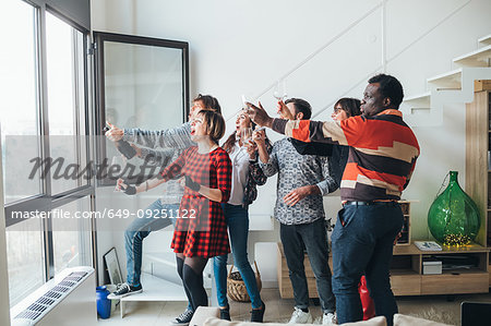 Friends taking selfie by window at party