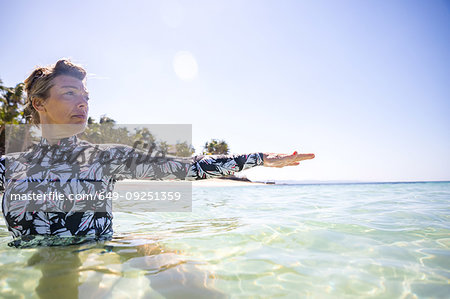 Woman stretching hand in sea, Pagudpud, Ilocos Norte, Philippines