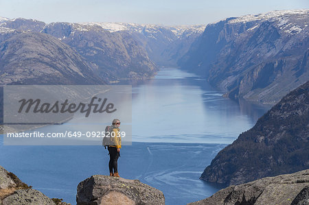 Hiker enjoying view on cliff top, Preikestolen (Pulpit Rock), Lysefjord, Norway, Stavanger