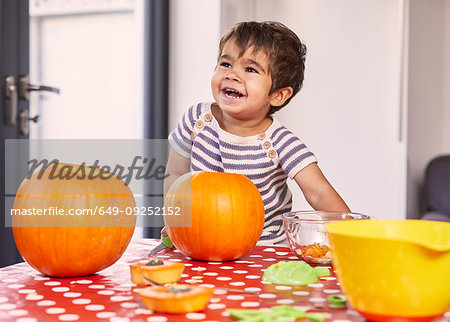 Boy carving pumpkin in kitchen