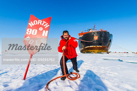 Man pretending to pull the Icebreaker '50 years of victory' on the North Pole, Arctic