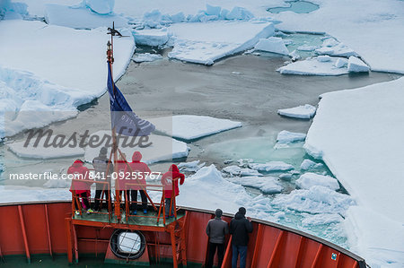 Tourists watching the ice breaking on board of an icebreaker, North Pole, Arctic