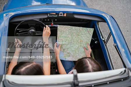 Friends reading route map inside car