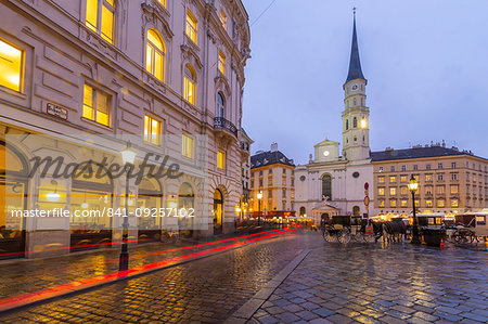 Christmas Market stalls and St. Michael Catholic Church in Michaelerplatz, Vienna, Austria, Europe
