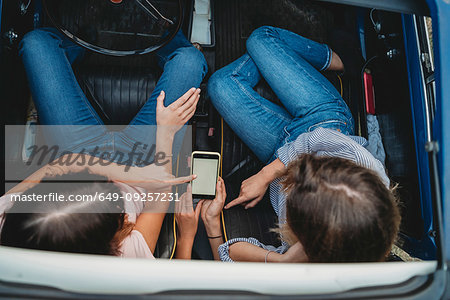 Friends using smartphone inside car