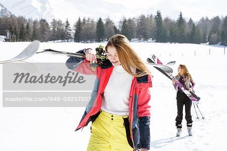 Two teenage girl skiers walking in snow covered landscape,  Tyrol, Styria, Austria