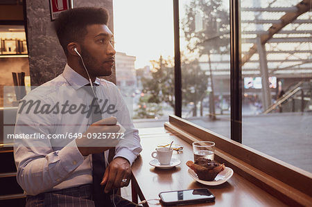 Businessman using smartphone at tea time in cafe