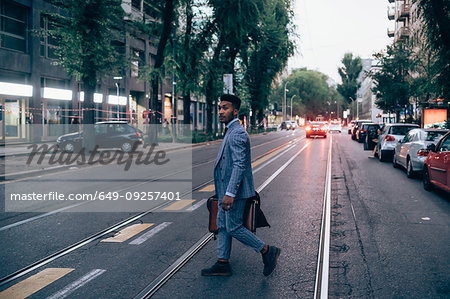 Businessman crossing road, Milano, Lombardia, Italy