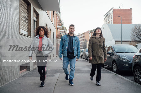 Friends play acting catwalk on pavement, Milano, Lombardia, Italy