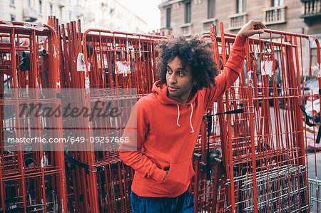Young man waiting beside steel frames