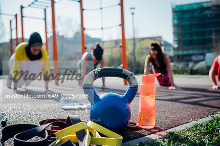Calisthenics class at outdoor gym, young women practicing yoga position, shallow focus