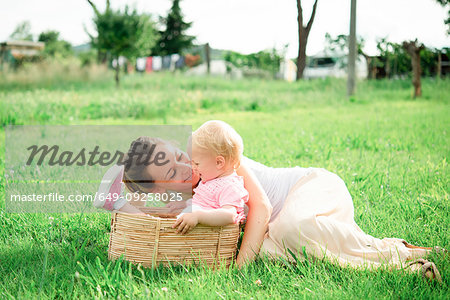 Mother lying on grass gazing at toddler daughter, Arezzo, Tuscany, Italy