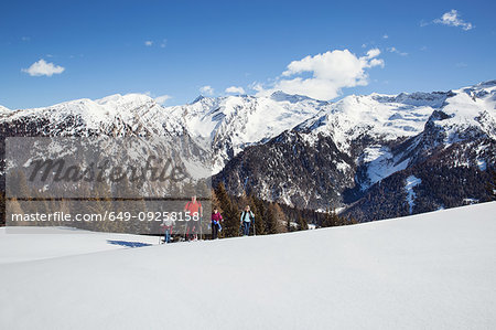 Mature couple and daughters snowshoeing in snow covered mountain landscape, Styria, Tyrol, Austria