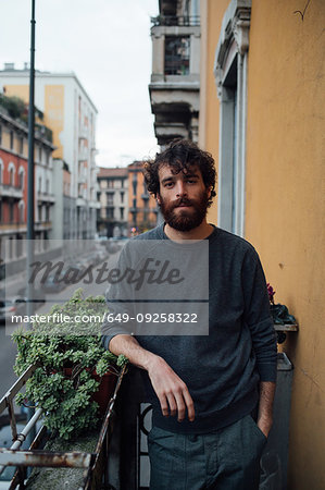 Bearded young man in deep thought on balcony