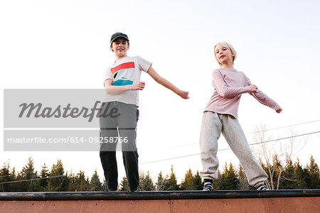 Boy and sister dancing on top of rural wooden structure