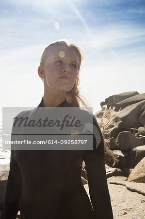 Young female surfer looking sideways on beach, Cape Town, Western Cape, South Africa