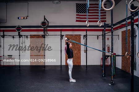 Young woman stretching arms in gym