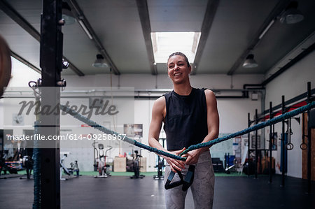 Young woman stretching arms in gym