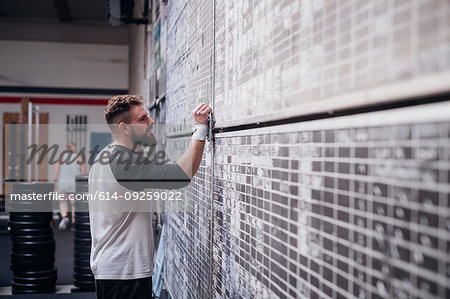 Young man writing on scoreboard in gym