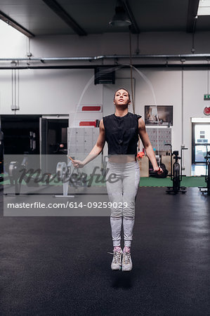 Young woman skipping in gym