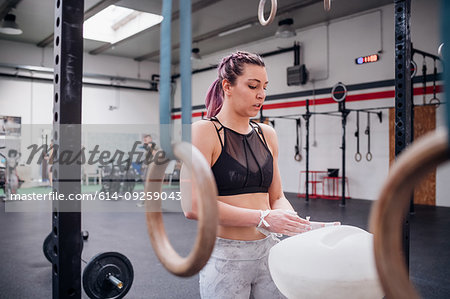 Young woman powdering palms in gym