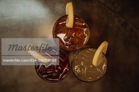 Three glasses of iced fruit drinks on cafe table, overhead view