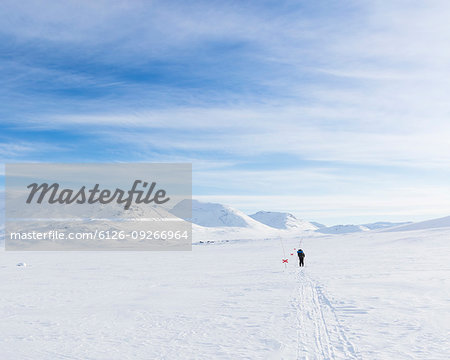 Woman skiing by mountains on Kungsleden train in Lapland, Sweden