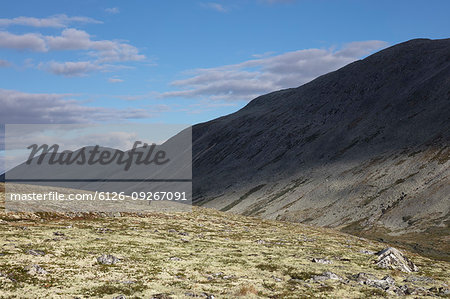 Man standing by hill in Rondane National Park, Norway