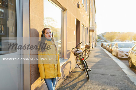 Girl wearing headphones on sidewalk