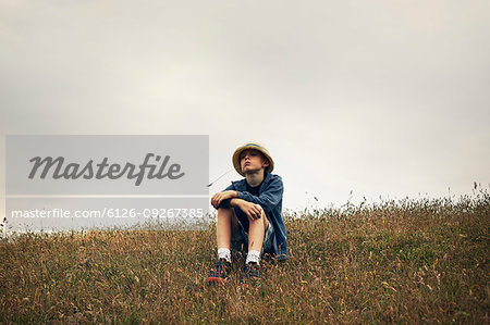 Boy sitting on hill