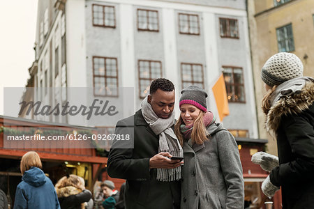 Couple looking at smart phone in market