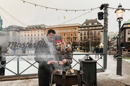 Couple warming their hands over fire