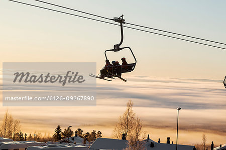 Silhouette of people on ski lift