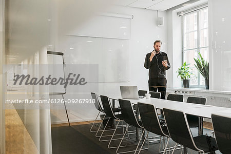 Man using smart phone in board room