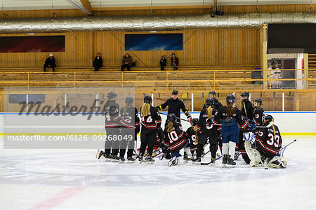 Girls listening to their coach during ice hockey training