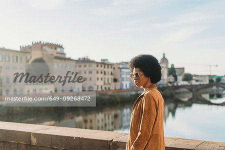 Young woman with afro hair crossing bridge, Florence, Toscana, Italy