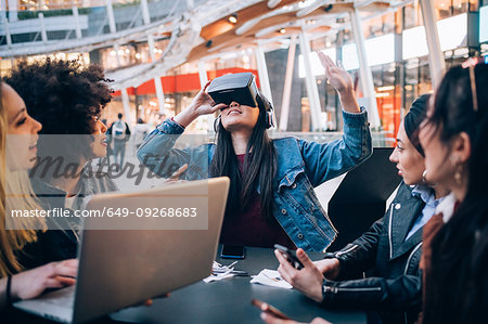 Friends working on virtual reality project at outdoor cafe, Milan, Italy