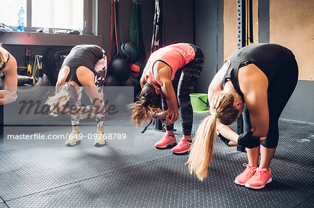 Women training in gym, bending forward