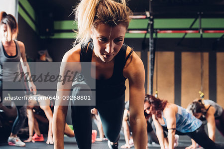 Women training in gym, leaning forward stretching