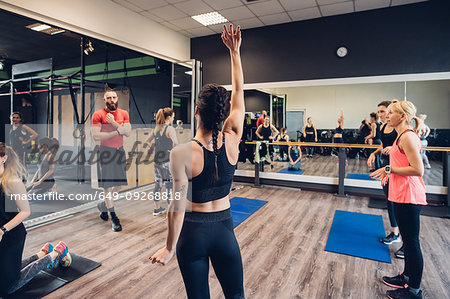 Group of women training in gym, questioning male trainer