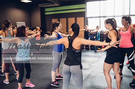 Group of women training in gym, with arms outstretched