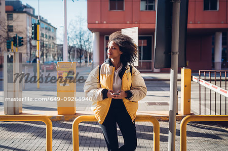 Cool young woman waiting at city tram station