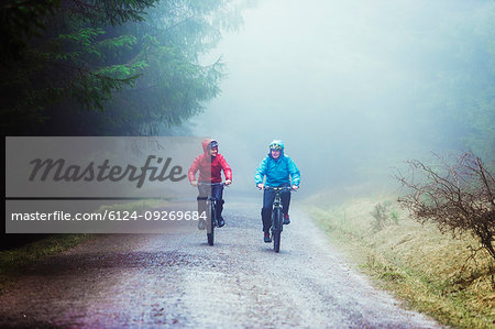 Father and son mountain biking in woods