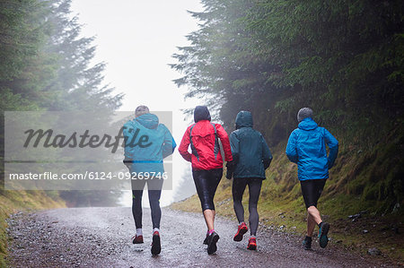 Family jogging in rainy woods